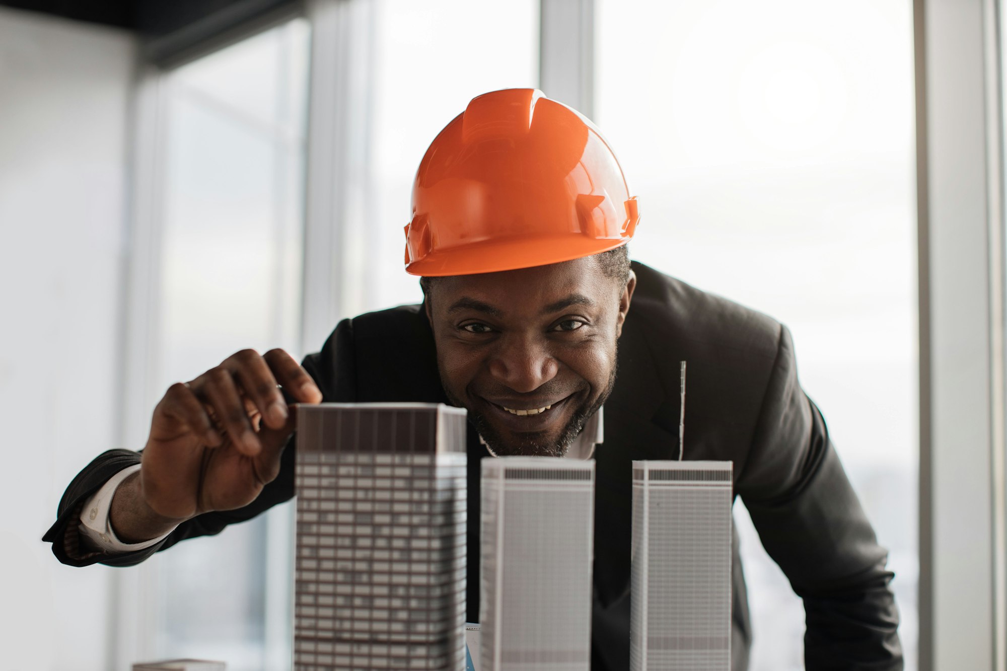 Close up portrait of smiling african american engineer, businessman in construction hard hat